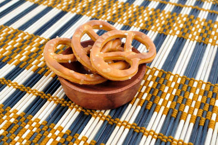 Three pretzels in the wooden bowl, on the sack clothの写真素材