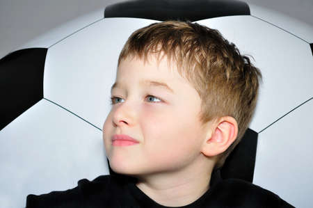 Little boy and big black and white footballの写真素材