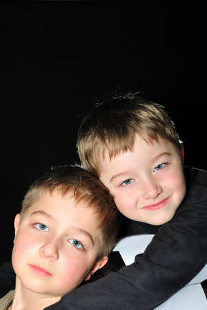 Portrait of two boys (brothers) on the football and a black background