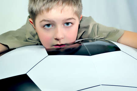 Little boy and big black and white footballの写真素材