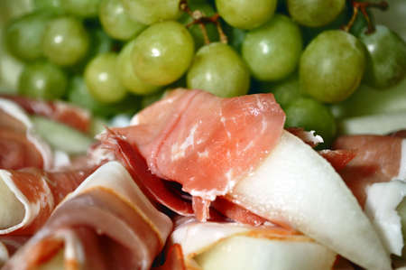 Muffled Melone little pieces and bunches of grapes in the backgroundの写真素材