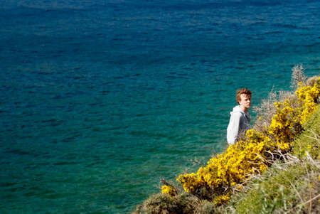 Boy on mountain edge to the sea