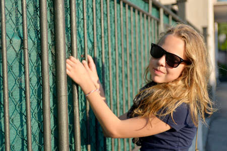 blond girl at the fenceの写真素材