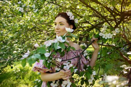 Young beautiful woman in pink dress at the gardenの写真素材