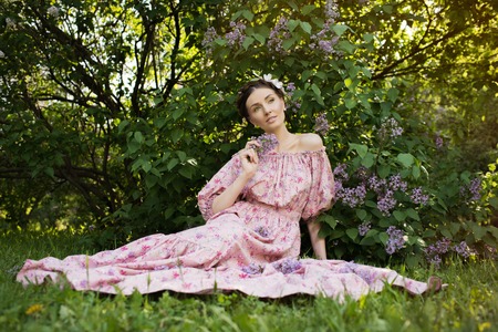 Young beautiful woman in pink dress at the gardenの写真素材