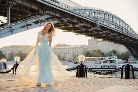 Beautiful girl at the river bank in the cityの写真素材