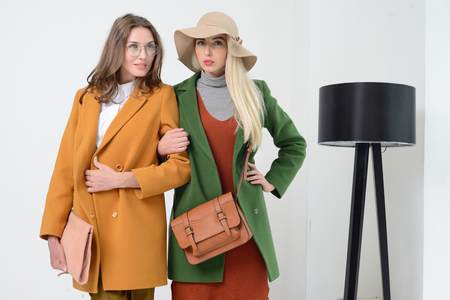 Young girls in studio posing in coatsの写真素材