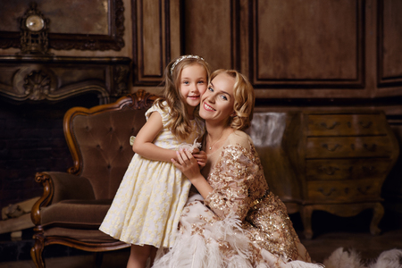 Young woman with daughter in classic interiorの写真素材