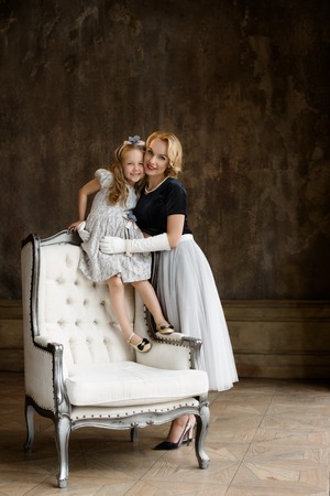 Young lady in retro dress with daughterの写真素材