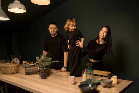 A harmonious family of three people in minimalistic images is photographed in the interior.