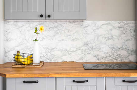 Modern minimal gray color kitchen with self adhesive fake marble imitation tape on wall, solid...