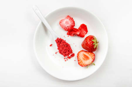 Strawberry powder made of freeze dried strawberries for sprinkle. Flavor and color ingredient for food. Top view, white minimal background, copy space. Great source of vitamin C and iron.の写真素材