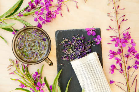 Flat lay view of Chamaenerion angustifolium( fireweed, great willowherb, rosebay willowherb) tea with dry and fresh blossoms for decoration. Herbal medicine concept.の写真素材