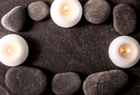 Frame made out of and black round smooth zen stones on black rough flat stone with white spa...