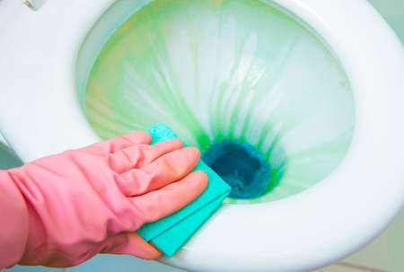Disinfection of toilet, using colorful antibacterial liquids and cleaning tools. Close up view.の写真素材