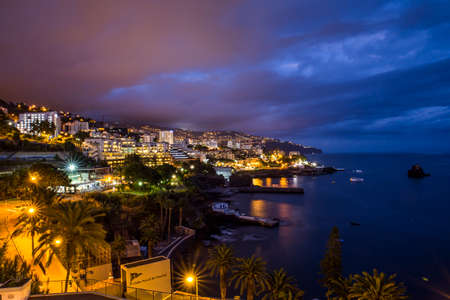 Funchal, Madeira, Portugal-09.04.2018: Long exposure shot of Funchal at night at hotel region, ocean, sky, mountains, cliffs on the background.の写真素材