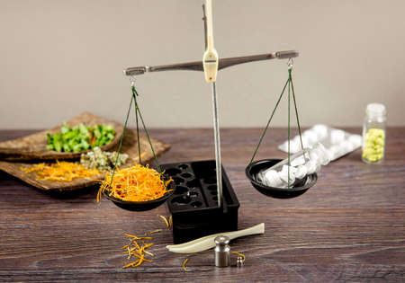 Healthy balance between herbal medicine and pharmaceutical drugs concept. Different medicament on vintage scale. Copy space, room for text.の写真素材