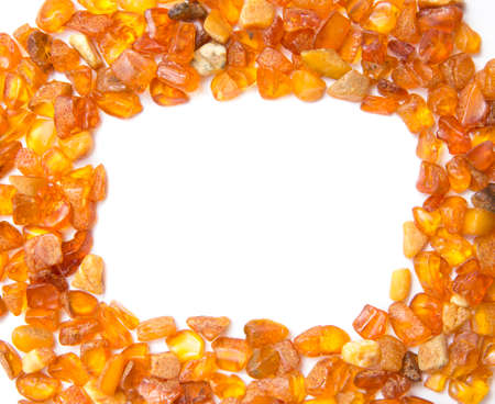 Frame made with chips of orange Baltic amber isolated on white. The Baltic region is home to the largest known deposit of amber, called Baltic amber or succinite. For making jewellery.の写真素材