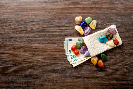 Lot of different color and type semi precious stones with euro money bank notes. Expensive hobby...