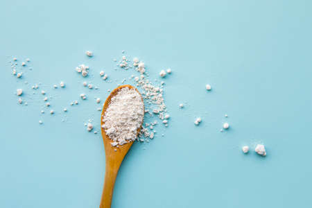 Diatomaceous earth also known as diatomite powder on wood spoon, good for human body detox concept....