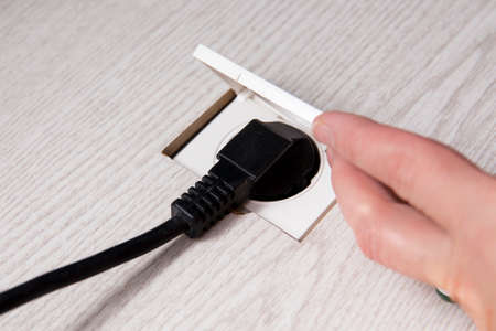 Electrical outlet socket with cover embedded in the floor. Reducing safety hazard concept.