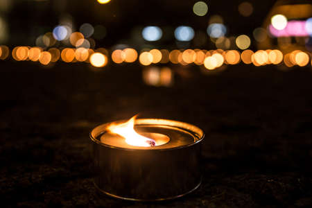 Selective focus on a lit outdoor candle(also known as pitch torch or a garden candle), a lot of out...