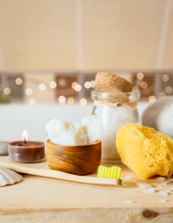 Using natural material products in home, different eco friendly cosmetic products in bathroom. Minimizing ecological footprint concept. Bamboo bath towel, biodegradable bamboo toothbrush, coconut oil.の写真素材