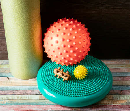 Massage yourself, composition of different tools isolated on white. Self-deep tissue massage concept. Spiky ball, foam roller, wooden roll, half balance rubber flat, full body massage tools.の写真素材
