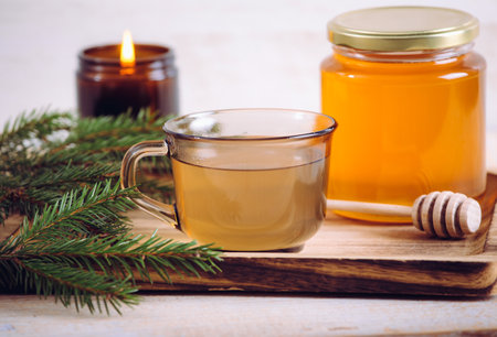 Spruce tree needle tea infusion with honey. Tree branches for decoration. Indoors home, healthy full of vitamin C. Cozy set.の写真素材
