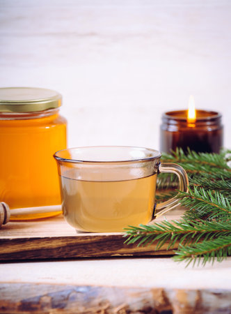 Spruce tree needle tea infusion with honey. Tree branches for decoration. Indoors home, healthy full of vitamin C. Cozy set.の写真素材
