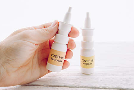 Person holding new treatment against Coronavirus COVID-19 nasal spray. Conceptual image of person...