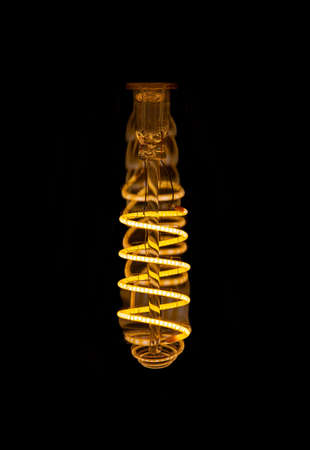 Close up view inside spiral LED decorative light bulb at dark. Copy space.の写真素材