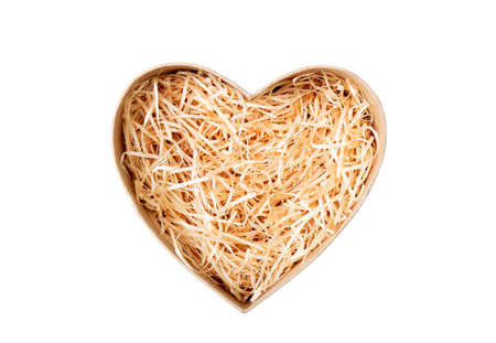 Top view of natural color open heart shape cardboard box with shredded wood excelsior for filling inside. Natural sustainable material for wrapping or products background. Isolated on white.の写真素材