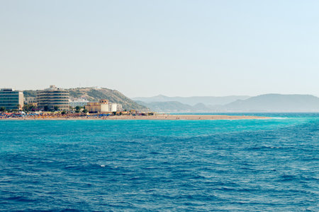 Popular Elli beach or Paralia Enidriou on island of Rhodes in Greece, Europe. Popular sandy city beach on sunny summer day, clear blue sky. Seen from sea.の写真素材