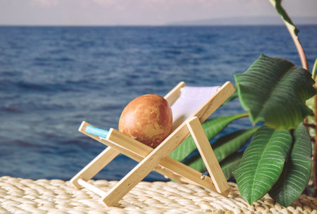 Easter egg on sunny sea beach vacation sit on sun lounger sun bathing, concept of Easter holiday vacation.の写真素材