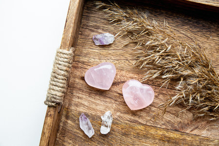 Pink color heart shape rose quartz on wood tray at home can also be used to attract love.
