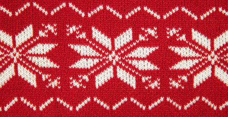 White color eight pointed star knitted pattern on sweater. White stars on red background, studio shot, indoors.の写真素材