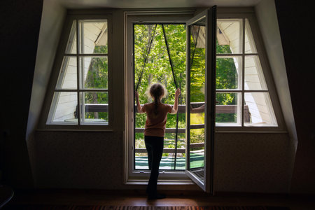Magnetic mosquito net mesh on balcony door. Child going outdoors to home balcony through, preventing insects coming inside.の写真素材