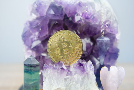 A gold Bitcoin coin resting inside an open amethyst quartz geode. Spiritual cryptocurrency and...