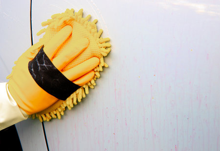A person is washing the car body with a sponge, using a cleaning agent that causes the rust...