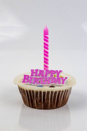 Cup cake with the words Happy Birthday and a candle.の写真素材