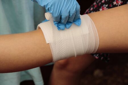 Applying a pressure bandage on a forearm