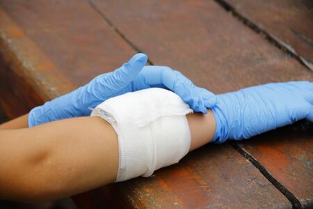Applying a pressure bandage on a forearmの写真素材