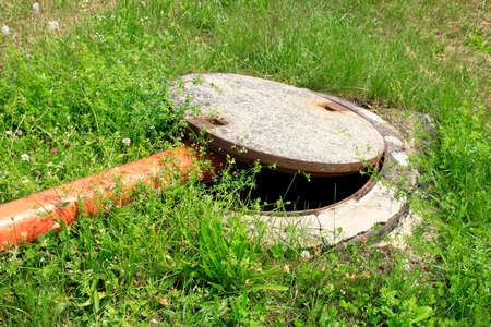 Wastewater is led into a sewer manhole through a pipeの写真素材