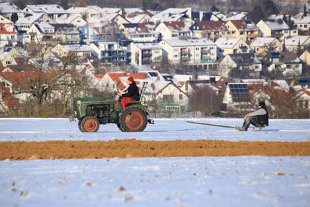 Tractor pulls sledders across a meadow in winterのeditorial素材