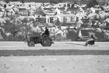 Tractor pulls sledders across a meadow in winterのeditorial素材