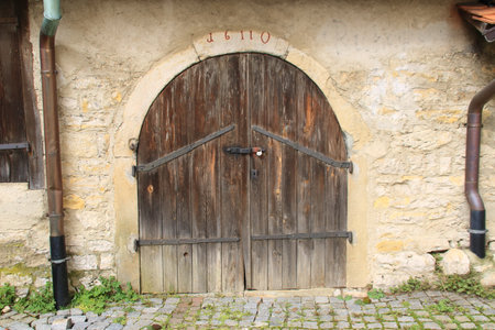 Old gate with a round arch in a house wallの写真素材