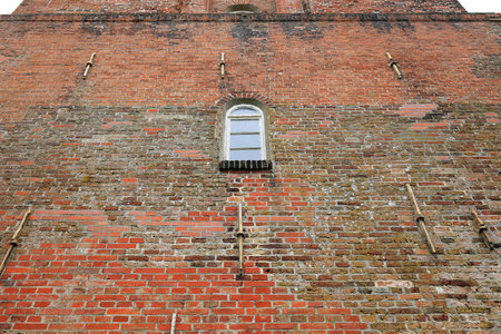 Window in the wall of the old lighthouse on the island of Borkumの写真素材