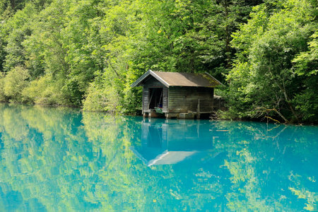 Small hut at the Klammsee in Kaprun is reflected in the water