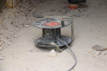 Cable drum lies in the dirt on a construction siteの写真素材